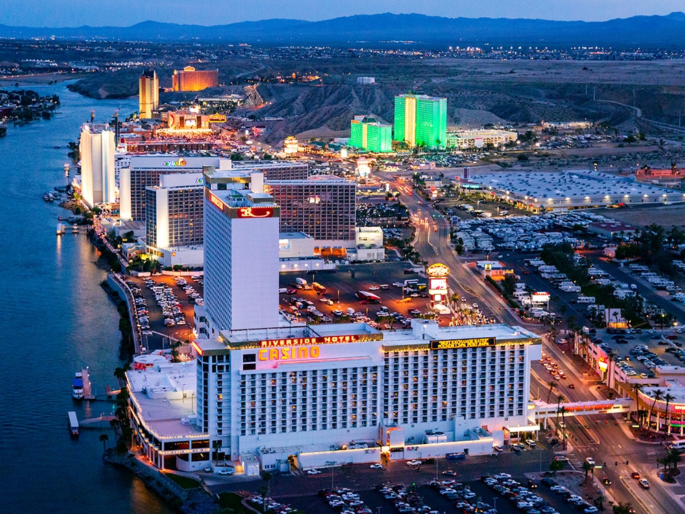 Aerial view of casinos awash in neon light at dusk.