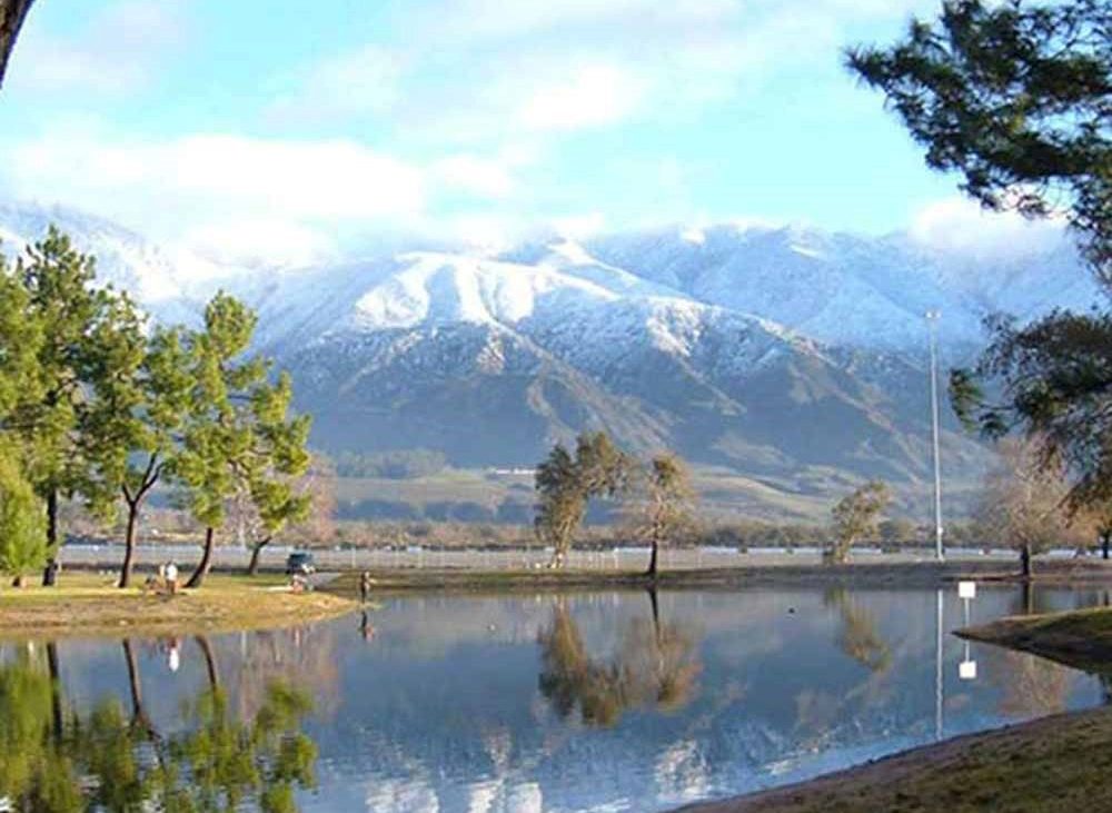 View of snowcapped mountains reflected on lake.