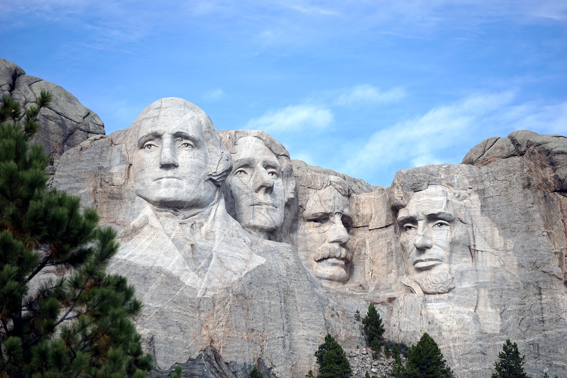 Frontal view of Mt. Rushmore under blue sky.