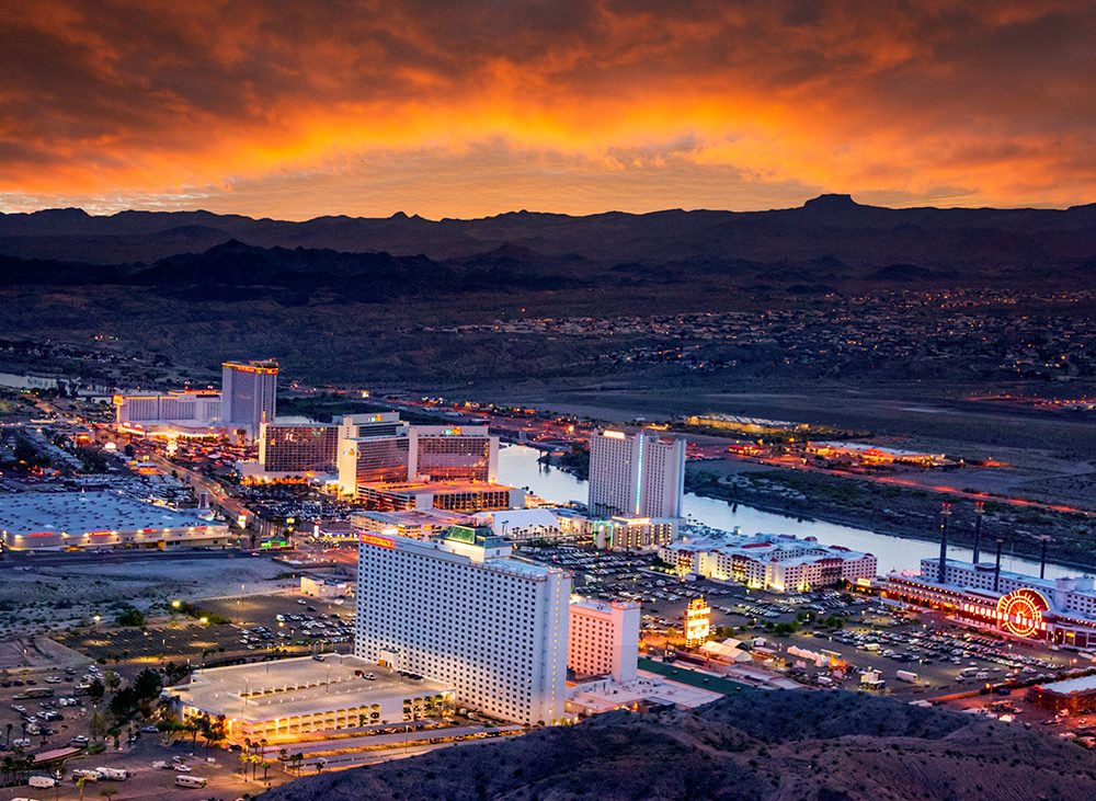 A dusk view of high-rise casinos overlooking a river.