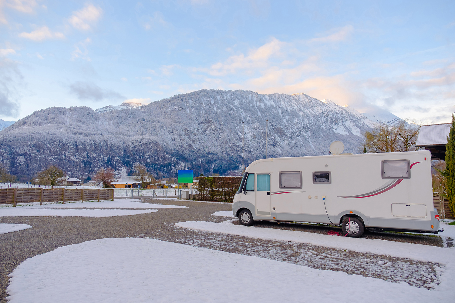 An RV in a snow-covered ccampground.