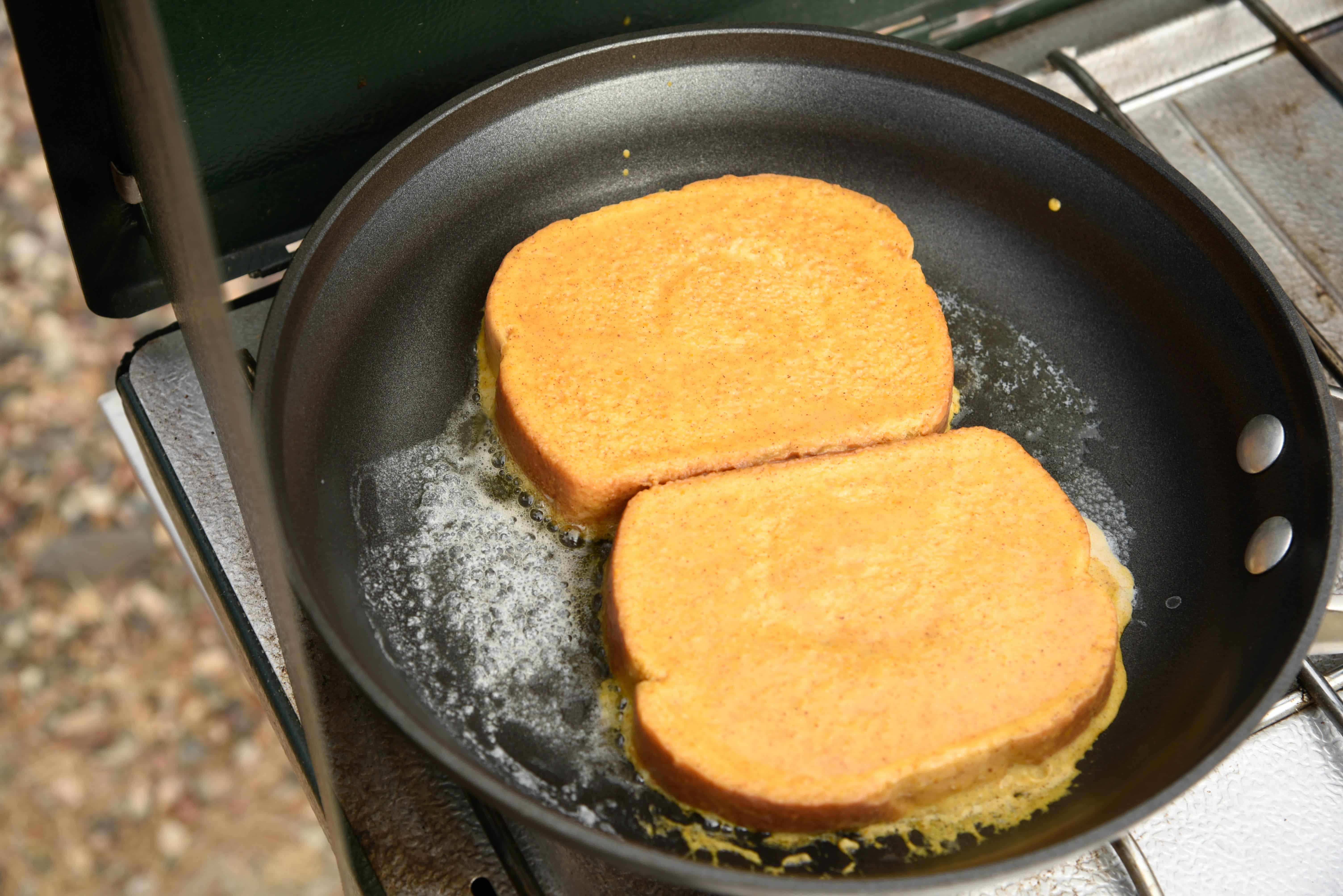 Batter-soaked bread frying in a pan