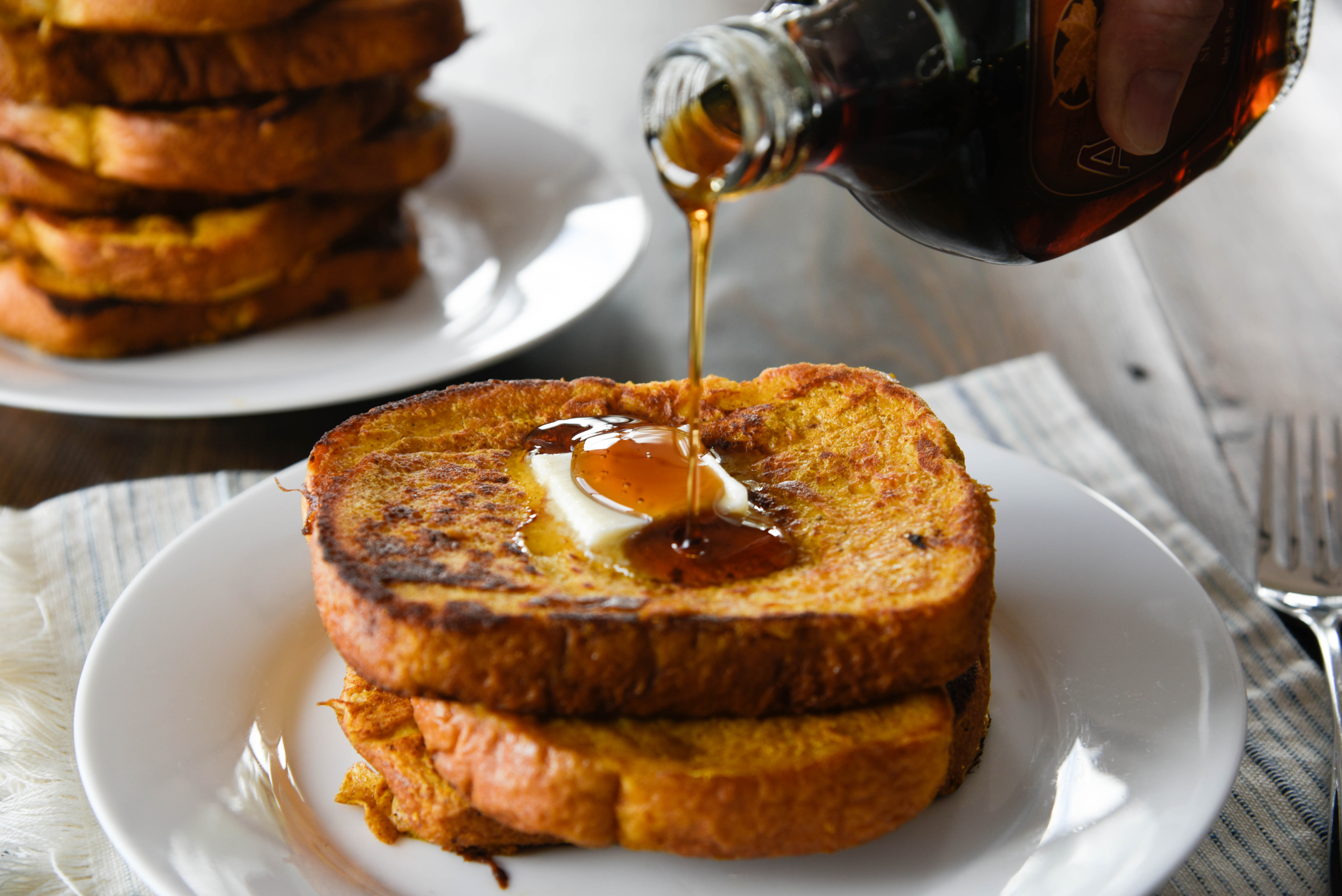 Syrup pouring over stack of French Toast
