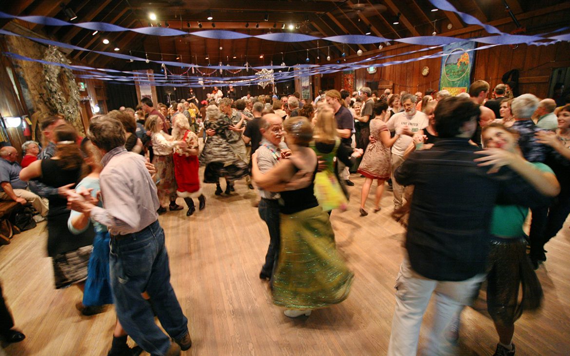 People square dancing in a barn.
