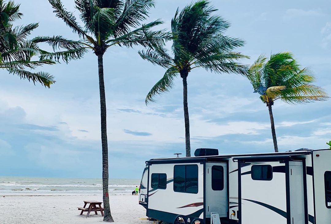 Camping under swaying palm trees on the beach