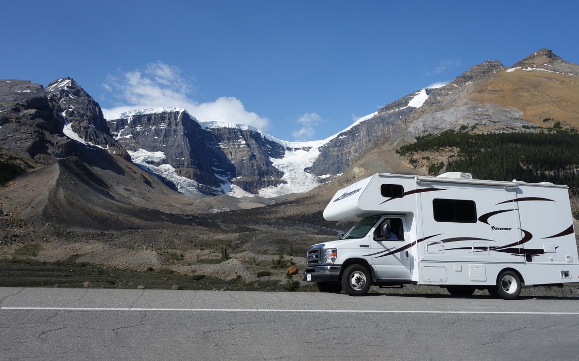 Class C motorhome with mountains in background.