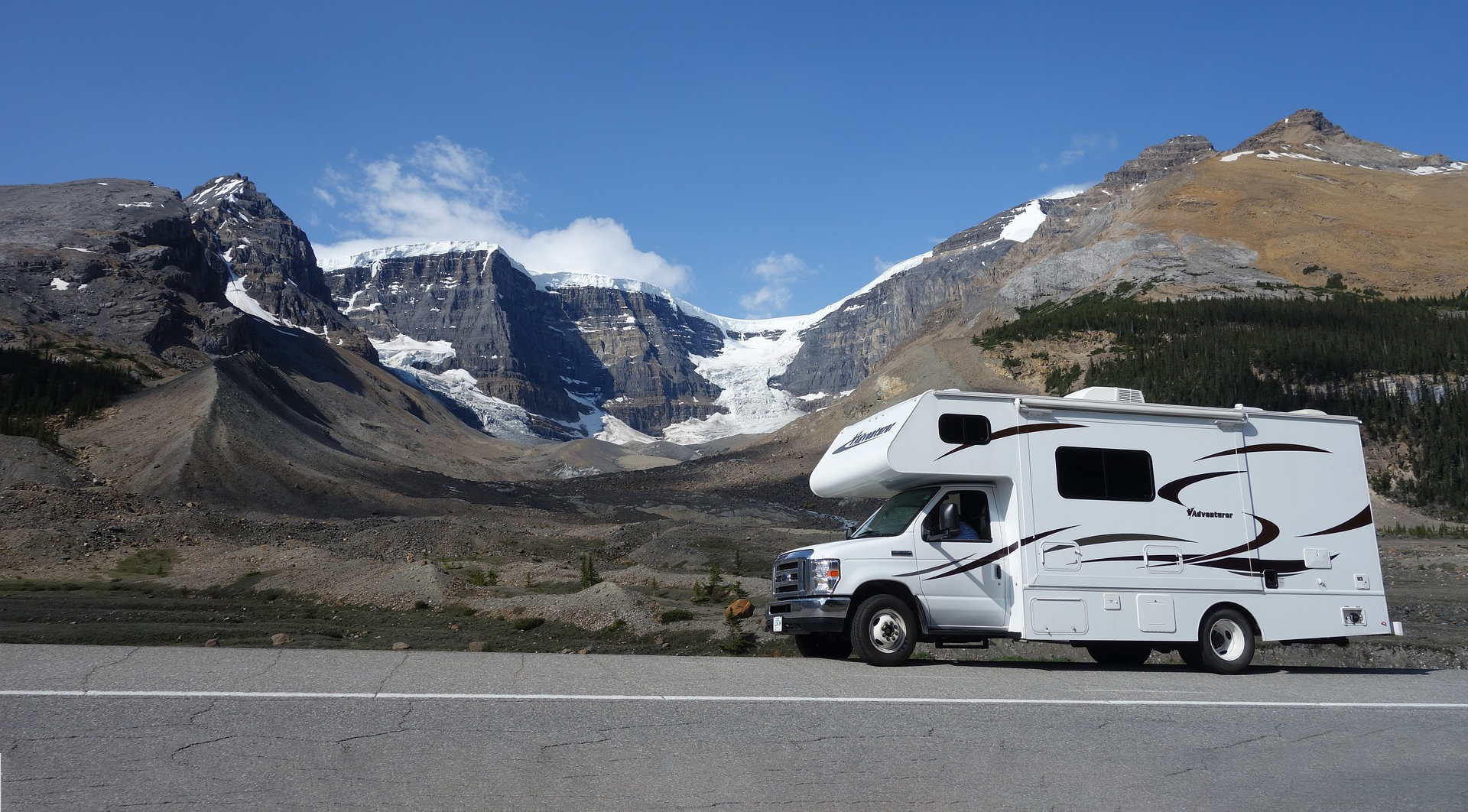 Class C motorhome with mountains in background.