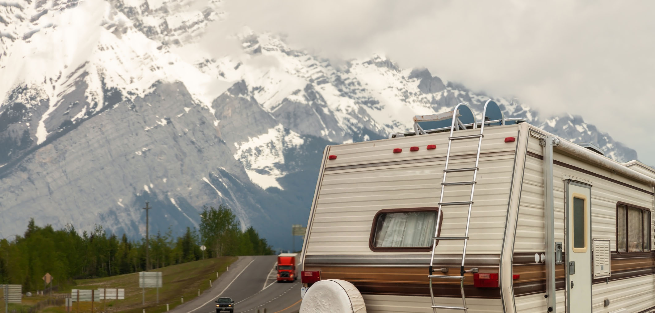 Travel Trailer with snowy mountain in background.