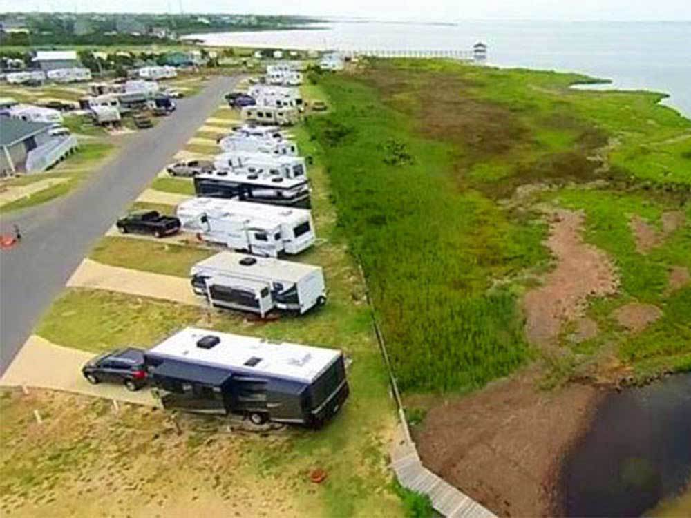 RVs parked diagonally along a coastline