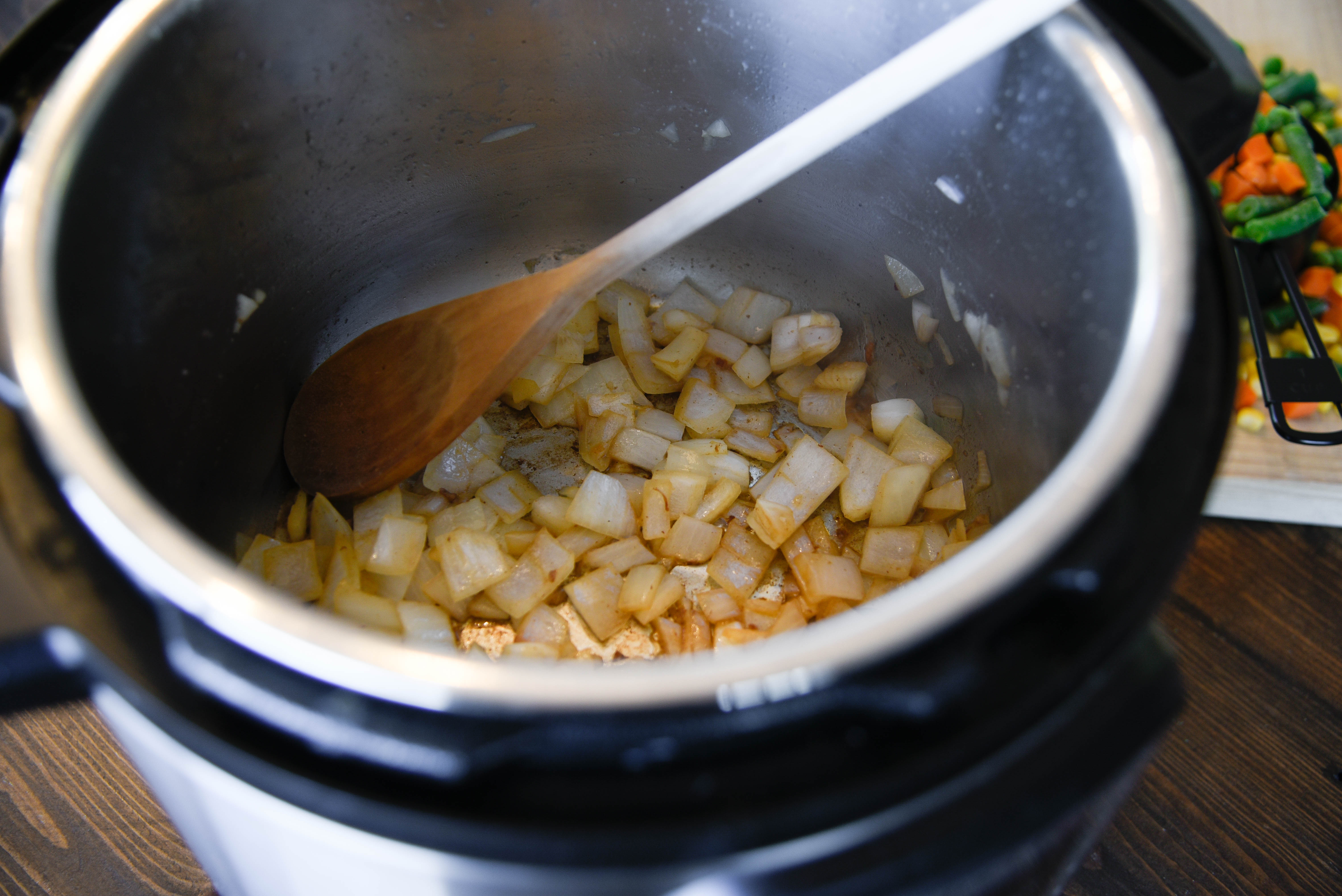 Onions carmelizing at the bottom of a pressure cooker.