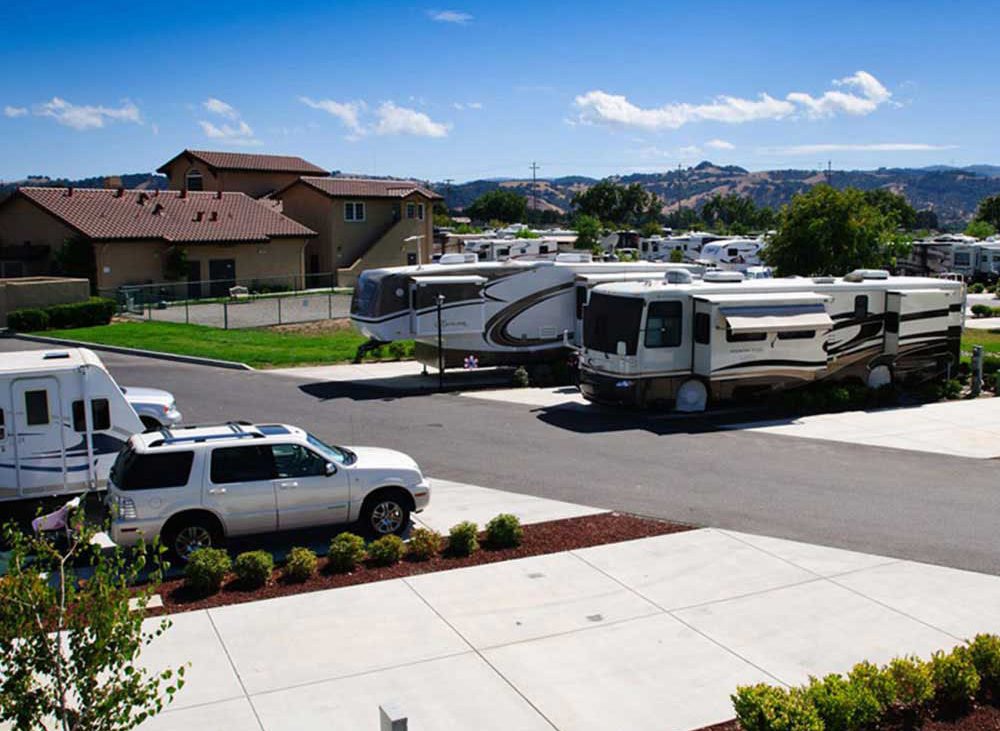 RVs and cars parked near a clubhouse