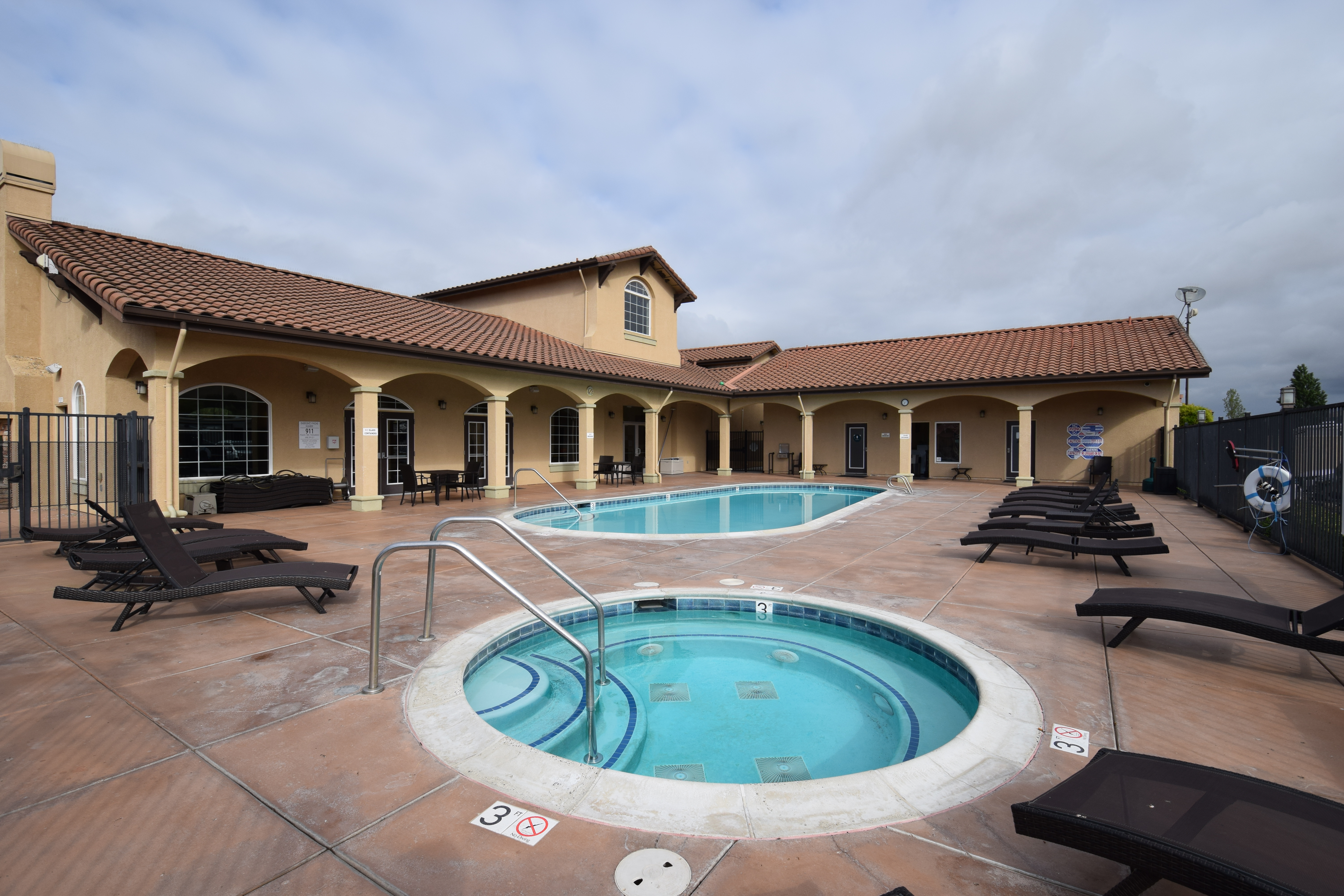 Swimming pool and hot tube with clubhouse nearby.
