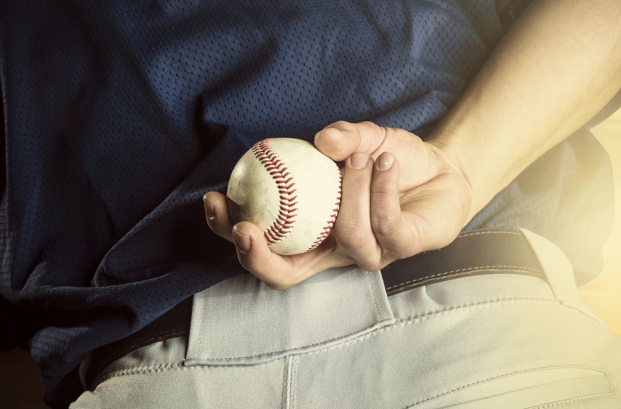 Baseball Pitcher A close up view of the baseball pitchers hand just before throwing a fastball in a game. Focus on the fingers and the ball