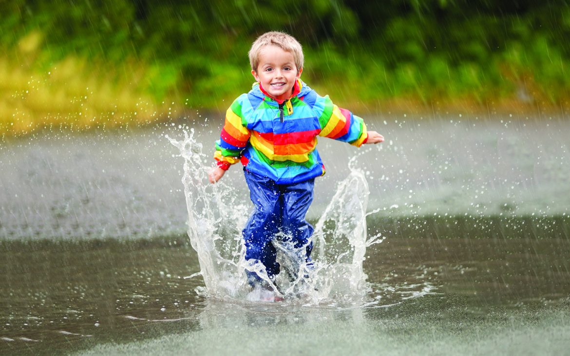 Keep Kid Entertained During rain — A kid jumping up and down in a puddle