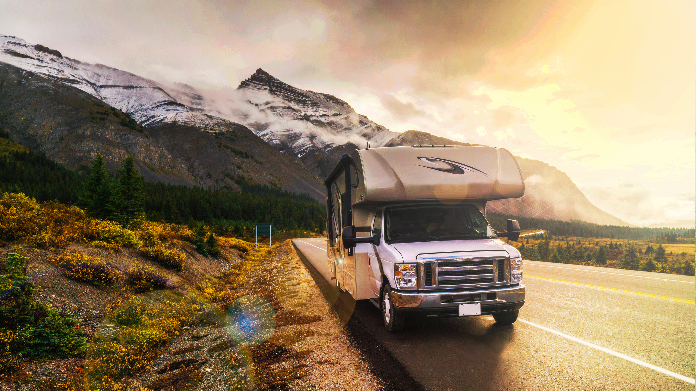 RV Leaks and Shaky Fivers -- RV on a highway winding through snow-capped mountains