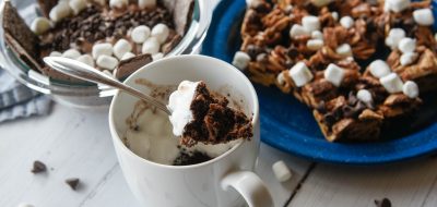 A cup of gooey cake with s'mores bars and dip
