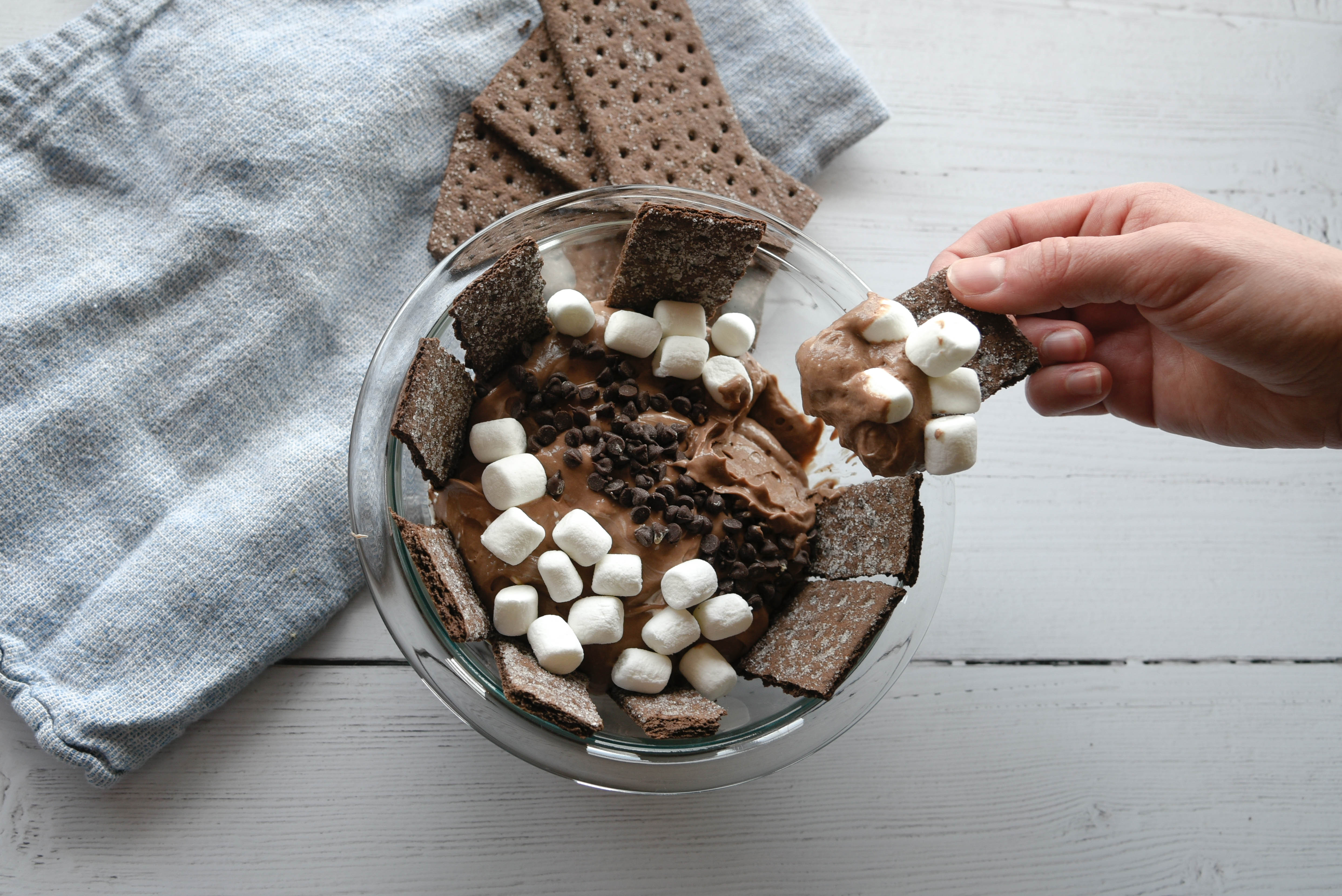 Dipping a Graham Cracker in a chocolate marshmallow concoction.