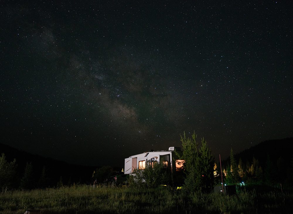 Picking the perfect campsite in Colorado — A fifth-wheel camping under a starry night sky.
