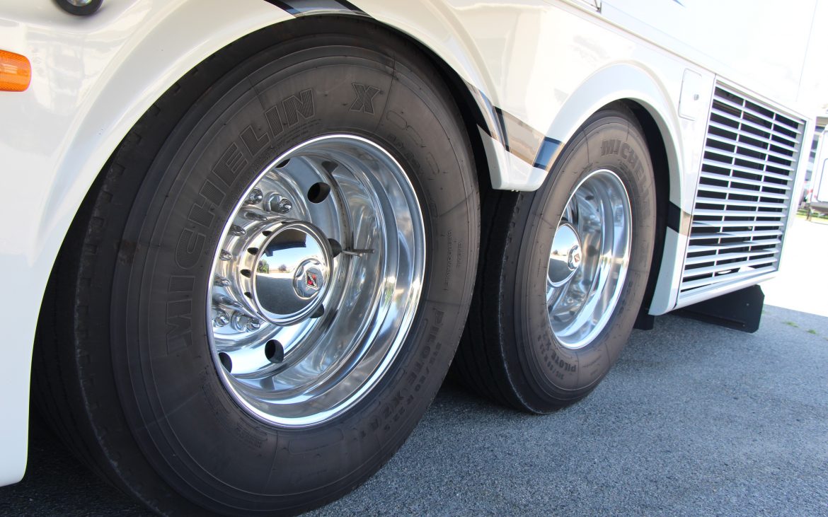 Low shot of tag axle-tires of motorhome on blacktop.