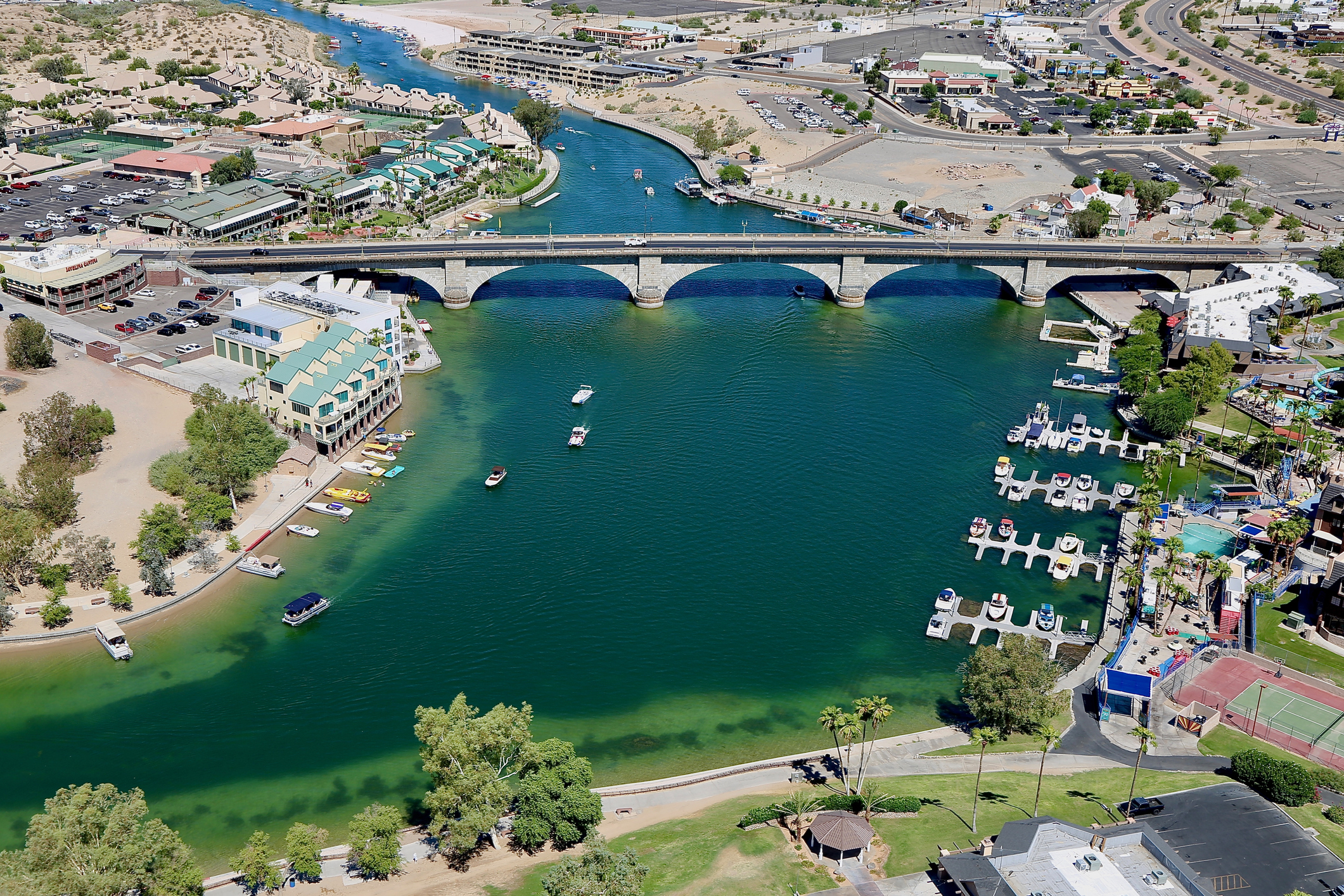 A bridge crosses a thin body of water aerial shot.