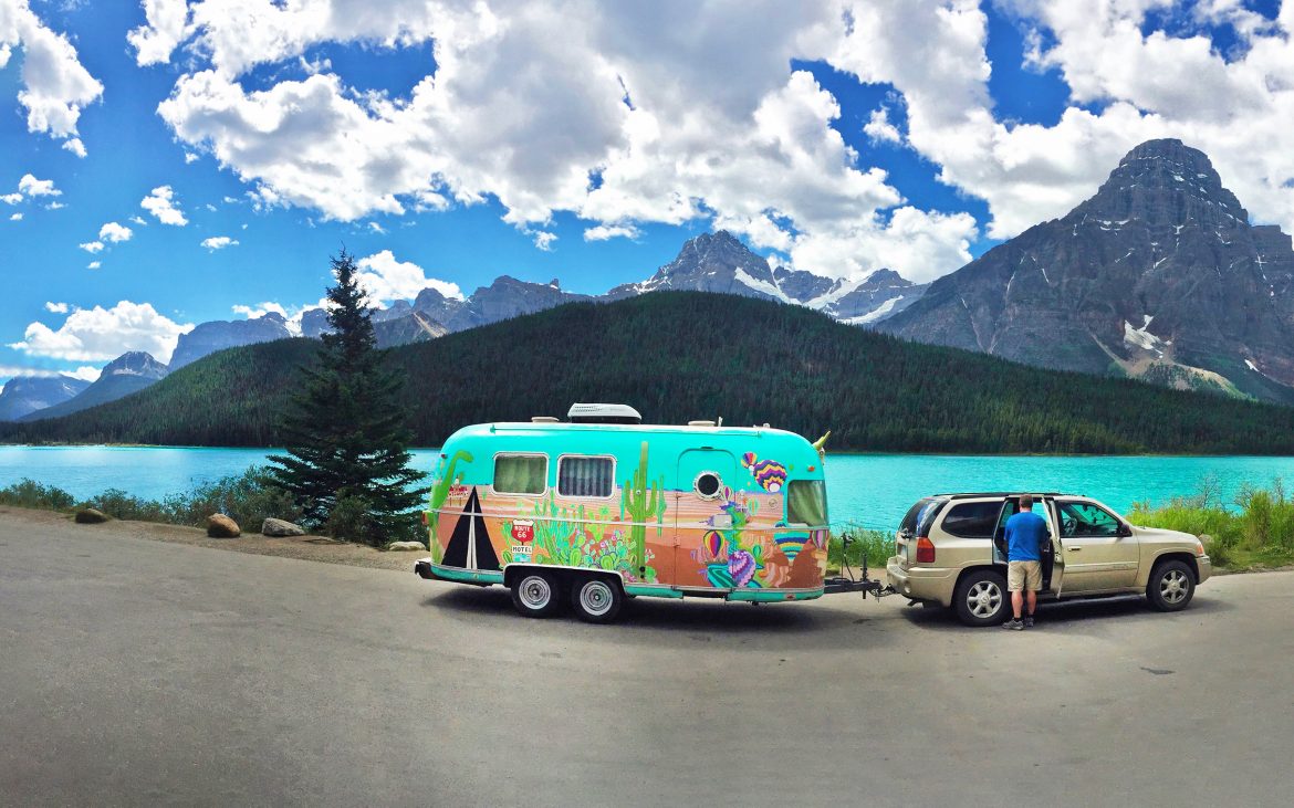 Banff and Jasper National Parks — A colorful airstream and tow vehicle parked in front of a turquoise lake.