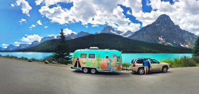 Banff and Jasper National Parks — A colorful airstream and tow vehicle parked in front of a turquoise lake.