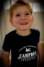 A boy wearing a black t-shirt with the Campboy logo on it