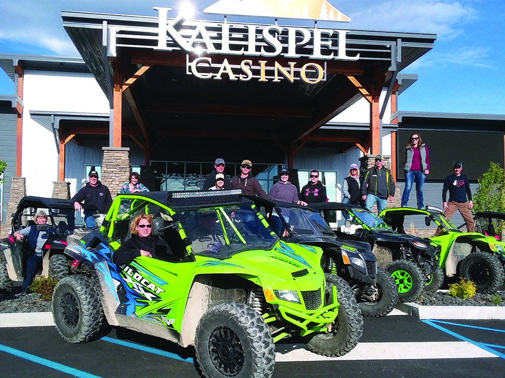 Outdoors enthusiasts pose around offroad vehicles in front of the Kalispel Casino.