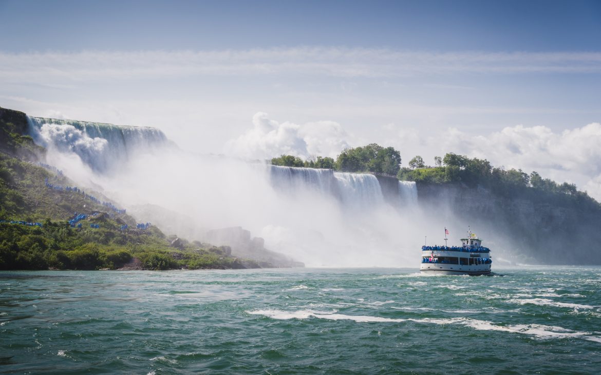 Perfect Family Vacation Spot — a tour boat chugs to the foot of niagara falls.