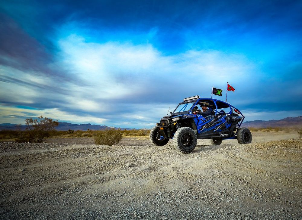 Visit Pahrump to hit the trails — an offroad vehicle races across a rugged landscape.