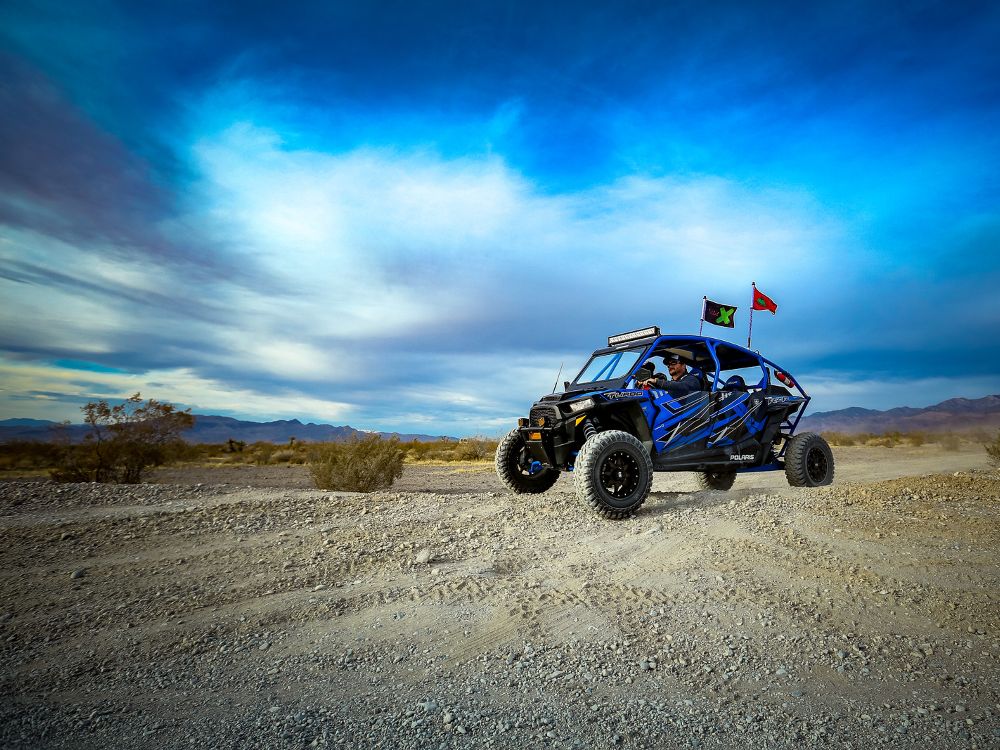 Visit Pahrump to hit the trails — an offroad vehicle races across a rugged landscape.