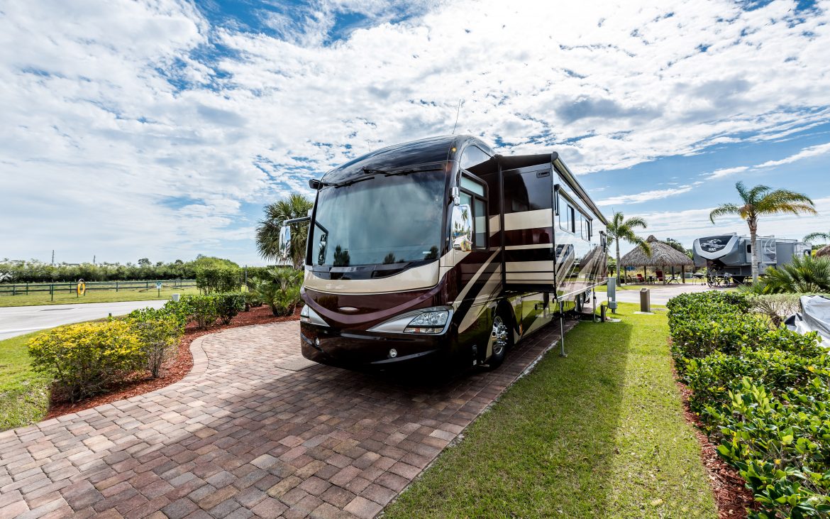 Florida fun to your weekends —Motorhome parked on a brick pad flanked by lush grass.