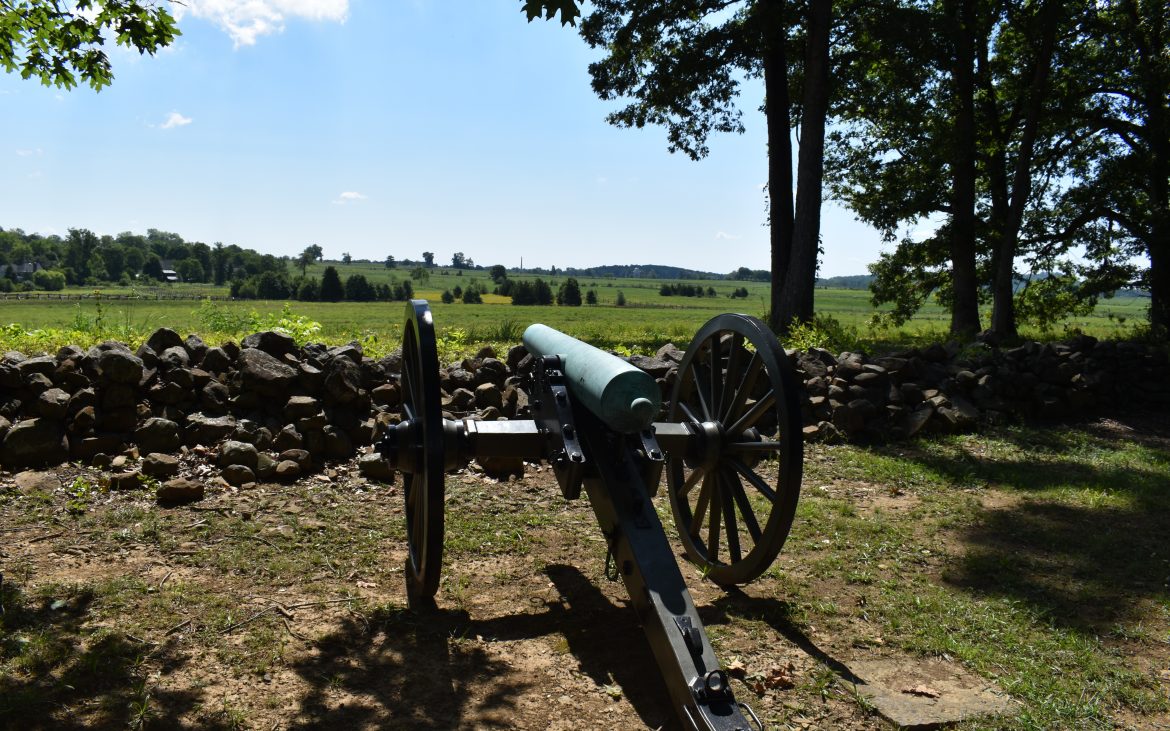 Historic Gettysburg — Cannon pointed at horizon under a clear blue sky.