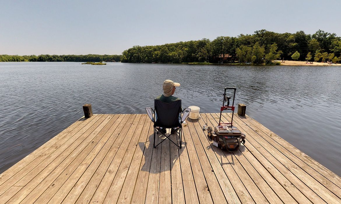 something for everyone in the family — a man fishing on a dock overlooking a beautiful lake.