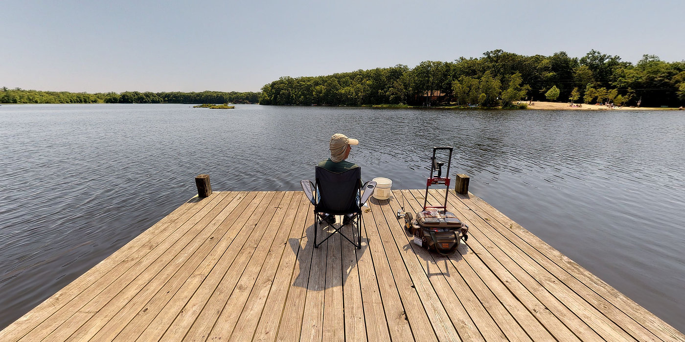 something for everyone in the family — a man fishing on a dock overlooking a beautiful lake.