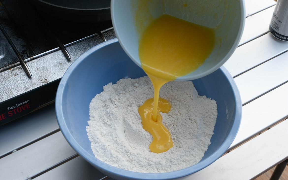 Whipped egg getting poured into bowl of flour