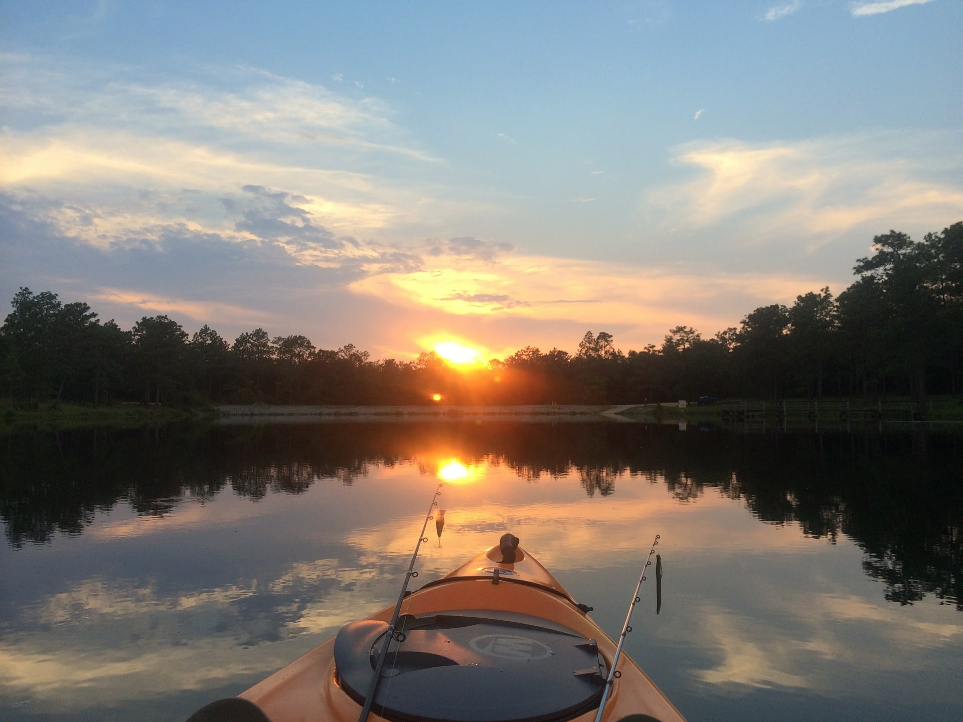 Kayak chasing sunset on forested channel
