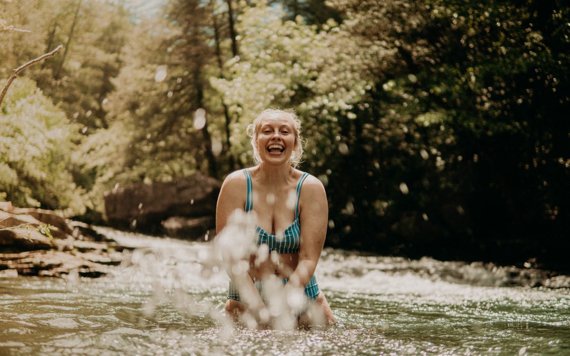Young woman splashing in stream