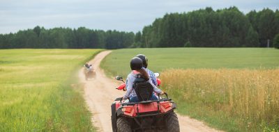 Good Sam Has Added 21 New Parks An ATV Quad sets out on a dusty trail toward a forest.