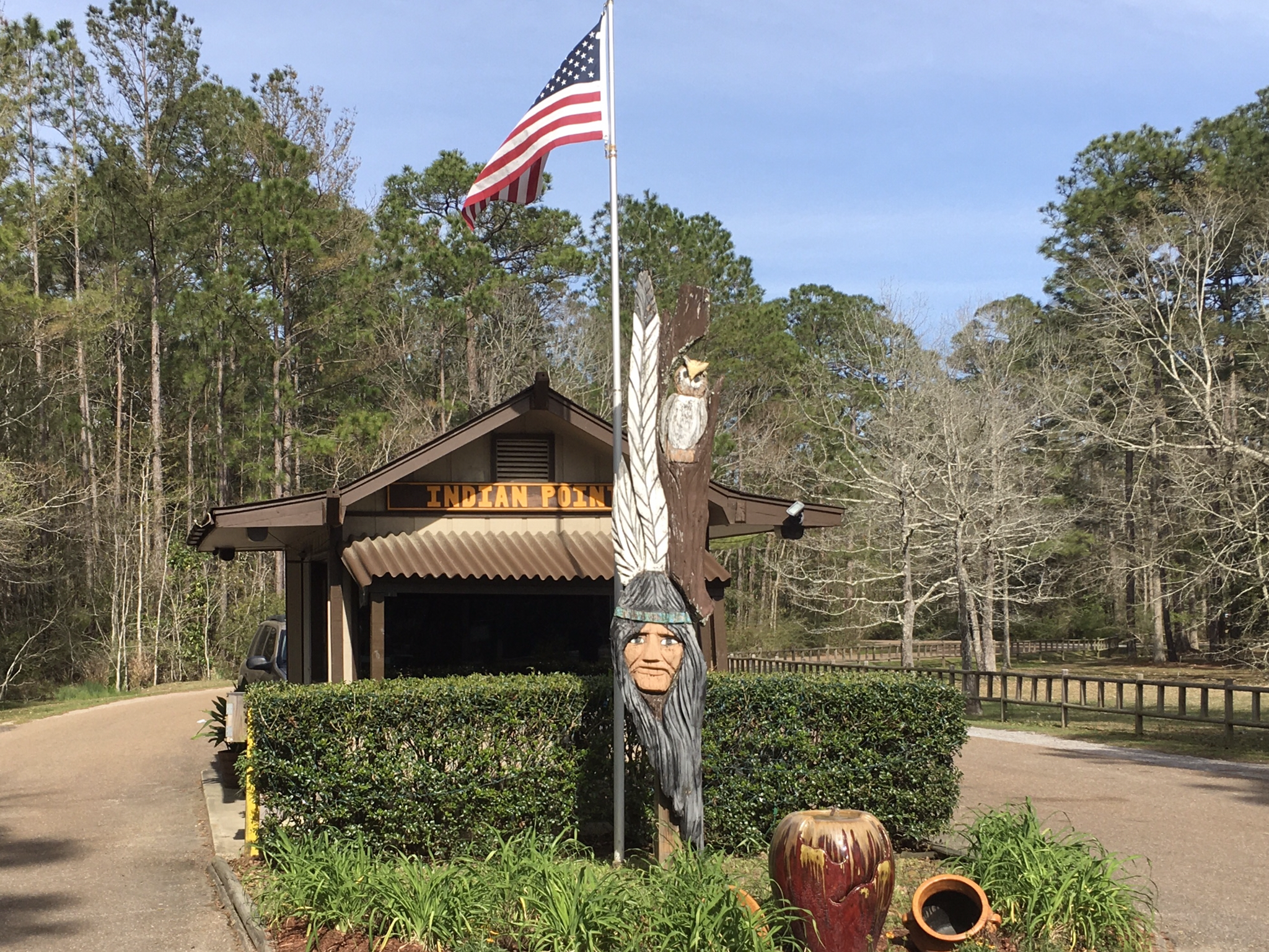 Stay in the Great State of Mississippi — a totem pole and American flag next to an entrance hut.
