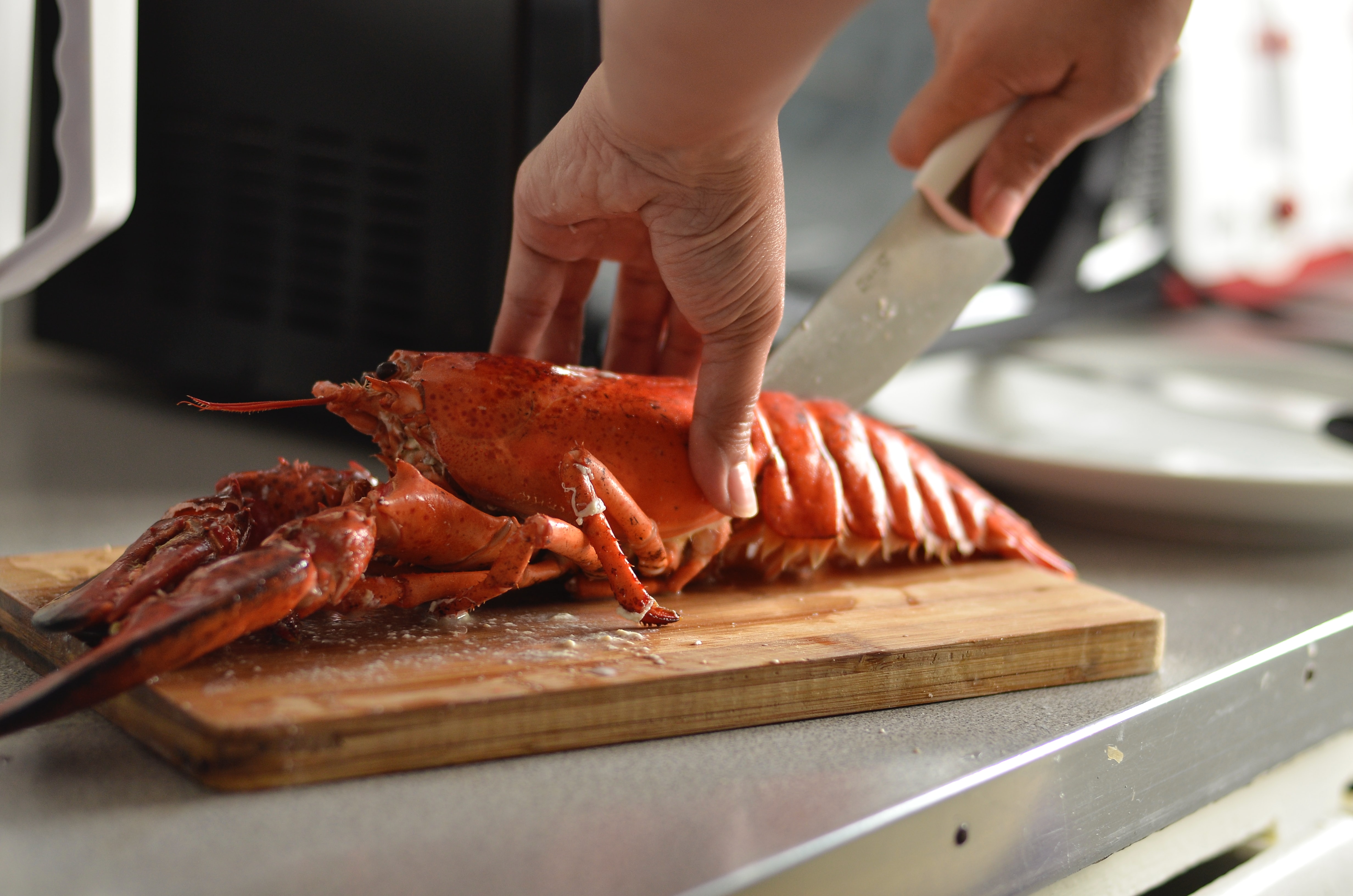 Cutting lobster on a cutting board.