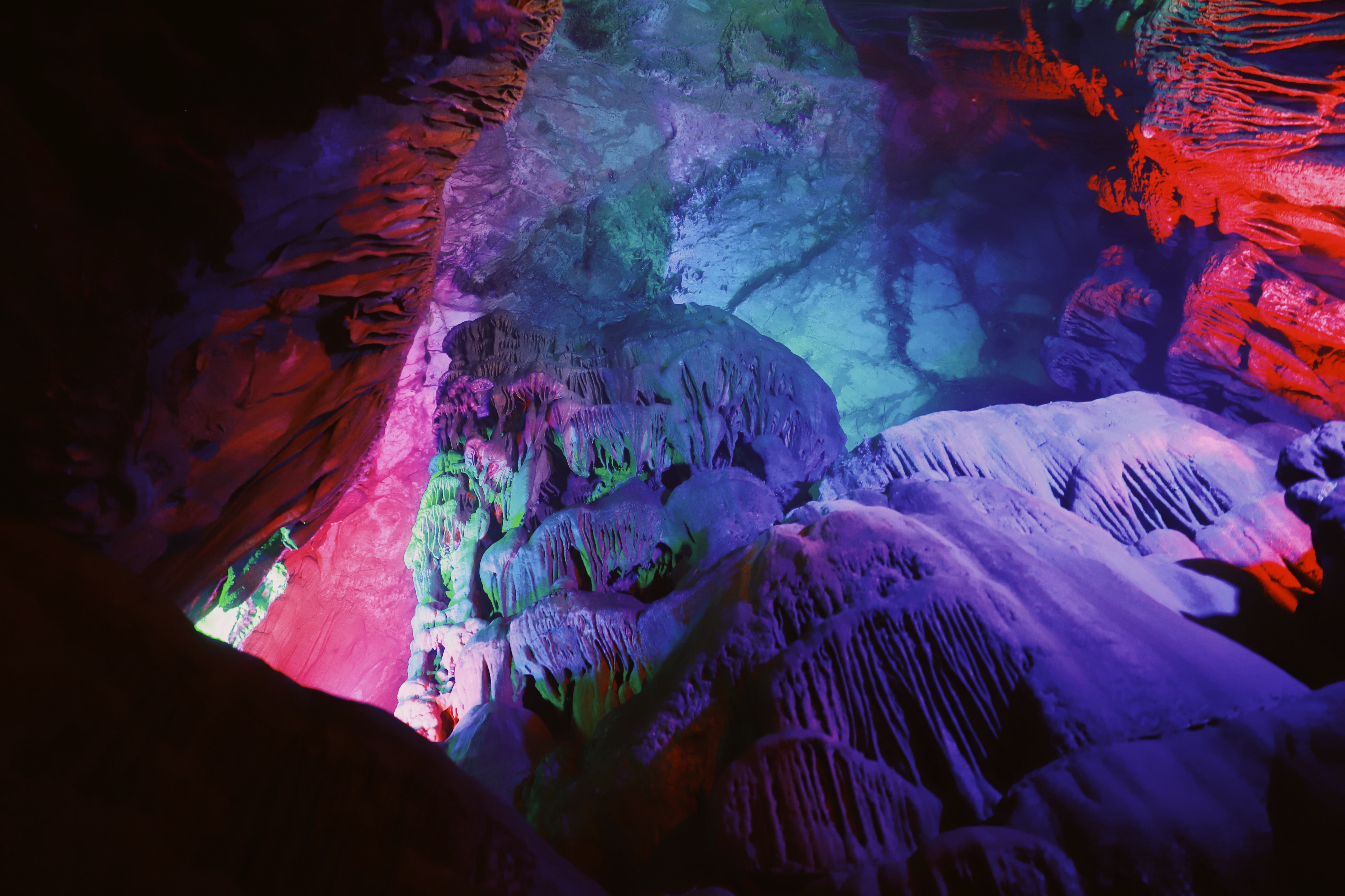 Lights reflect purple against cave walls and ceilings.