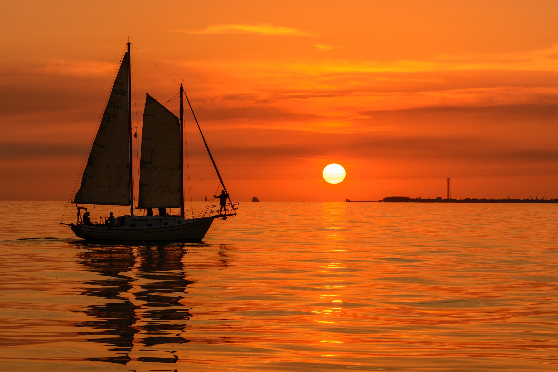 A yawl silhouetted against a red sunset. 