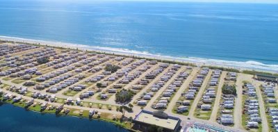 Aerial shot of RV park on an isthmus surrounded by ocean.