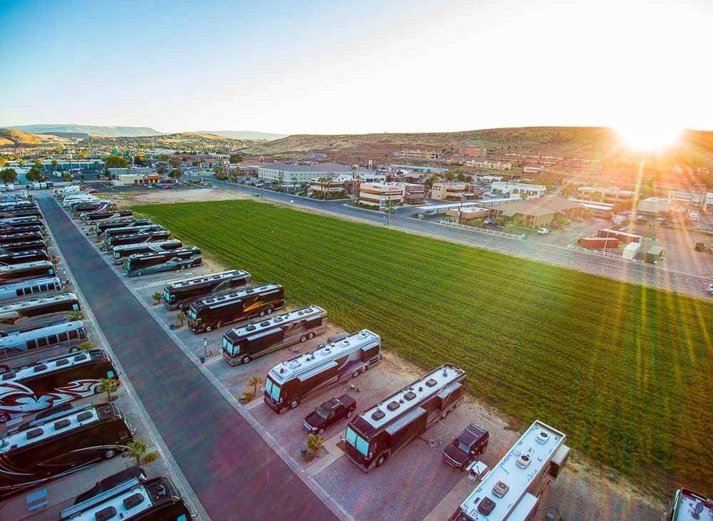 Sun sets over immaculate rows of motorhomes in an RV resort