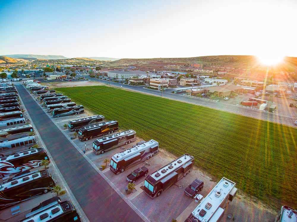 Sun sets over immaculate rows of motorhomes in an RV resort