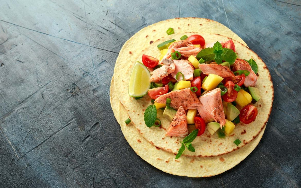 Kid-friendly recipes — Salmon fish tacos with mango, avocado, tomato, spring onion and lime. Mexican food