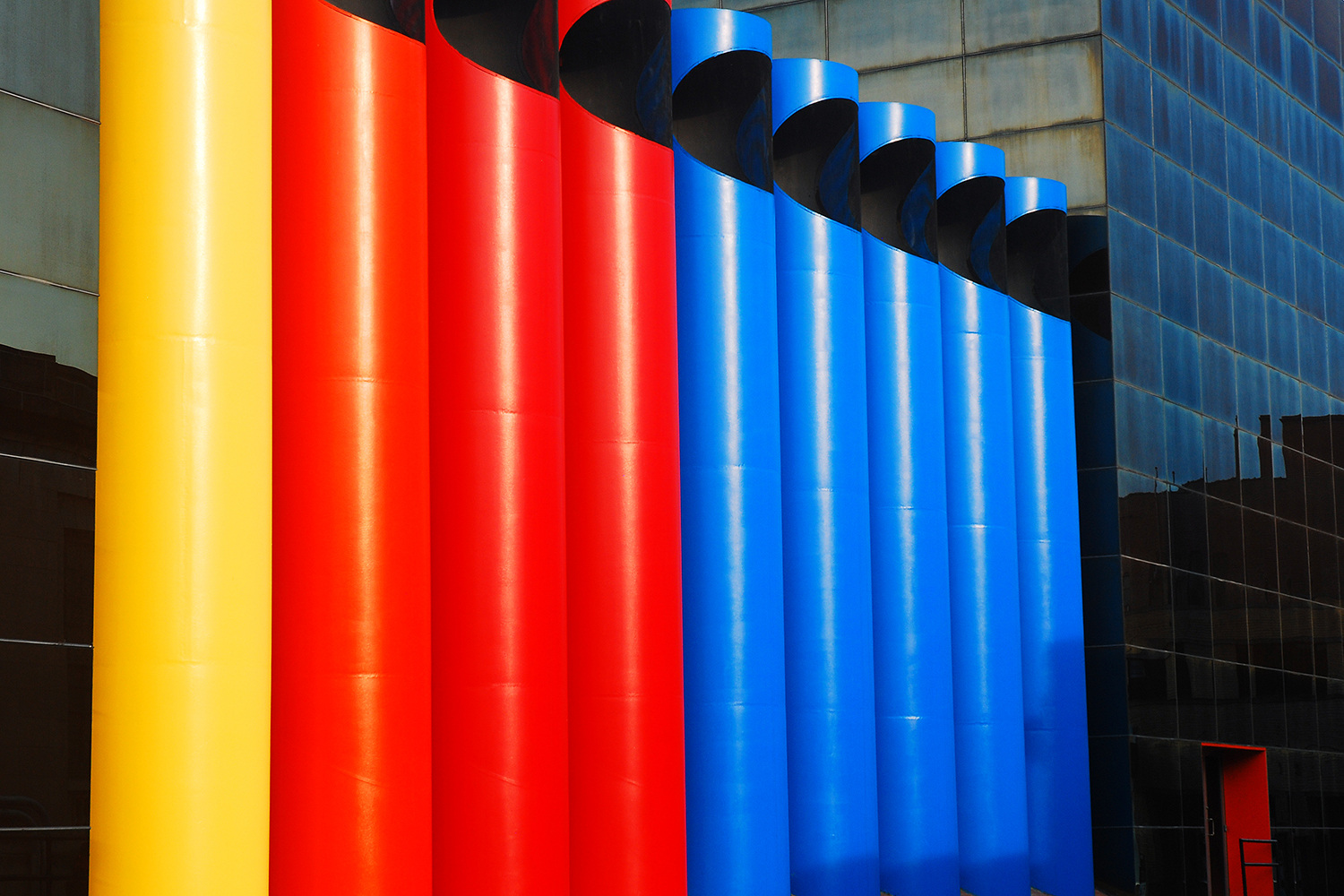 Colorful sculpture of exhaust pipes in primary colors.