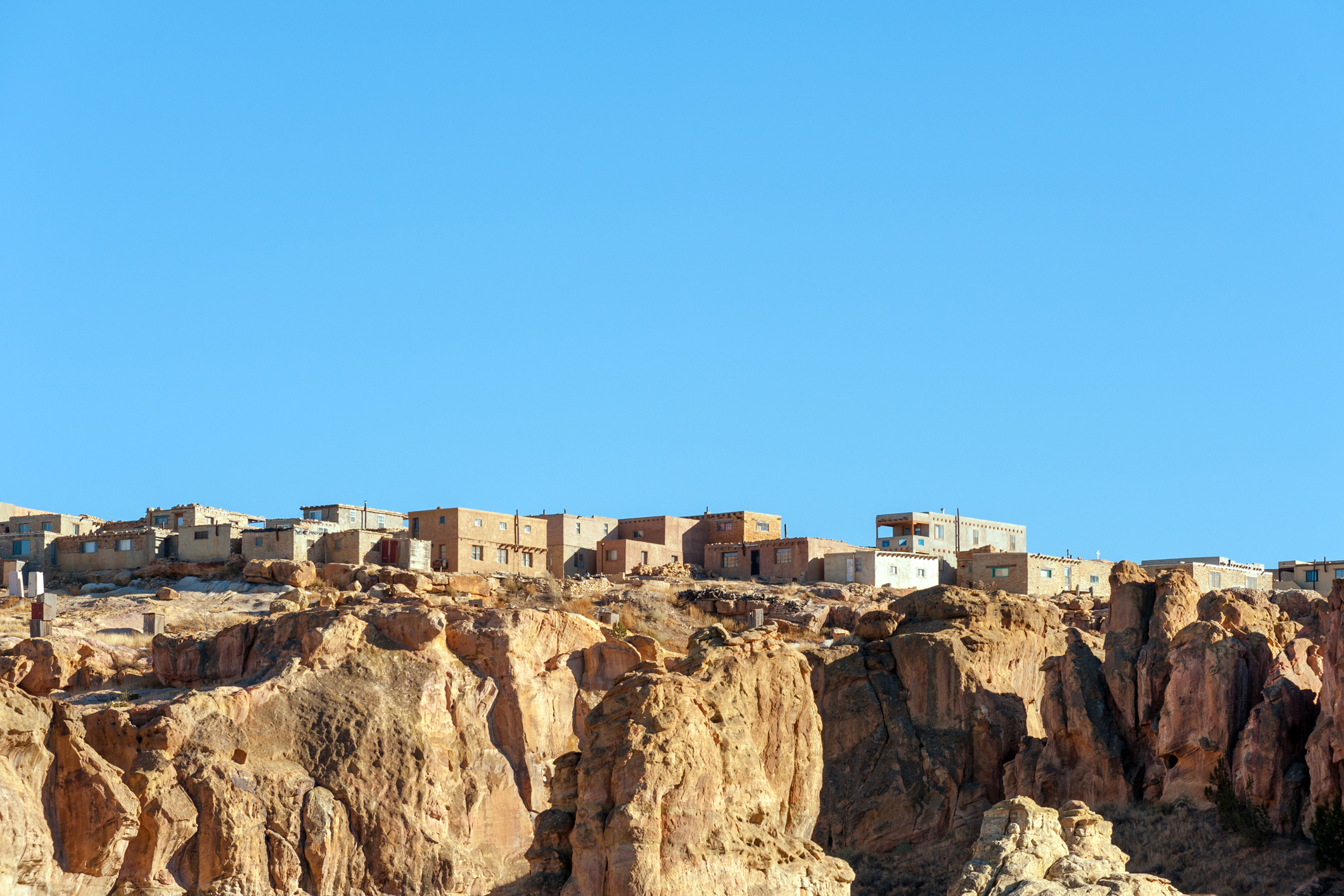 Adobe buildings perched atop a bluff.