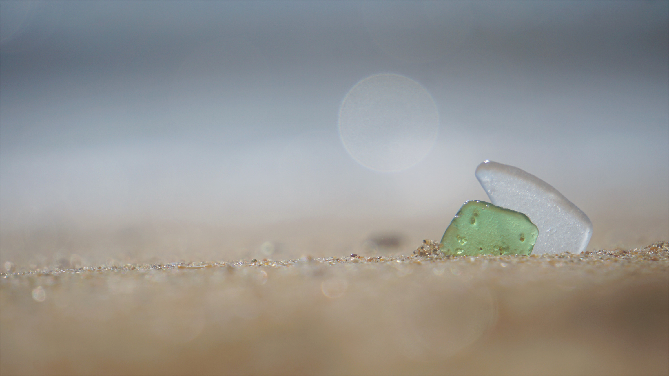 Seaglass embedded in sand.